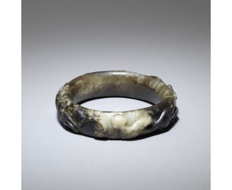 A black and white jade 'chilong' bangleMing Dynasty Thickly carved from a mottled black and white stone with three chilong cr