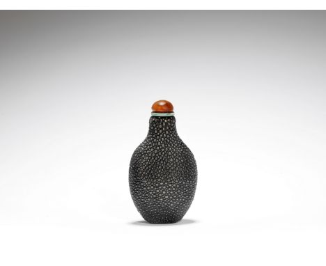 A 'shagreen' snuff bottle19th centuryOf compressed baluster form, with agate stopper and metal spoon.6.7cm (2.5/8in) high (2)