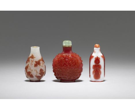 Three red overlay glass snuff bottles19th centuryComprising: a red overlay on snowstorm glass 'nine chilong' pear-shaped bott