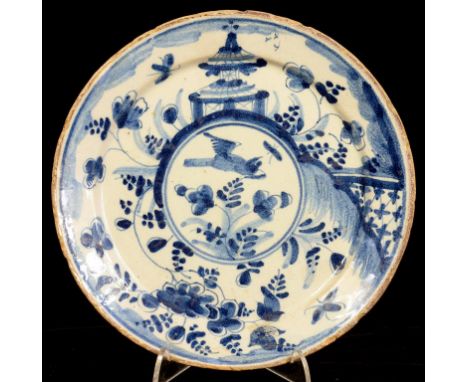 AN ENGLISH DELFTWARE CHINOIISERIE PLATE, PAINTED TO THE CENTRE WITH A BIRD AND FLOWERS, 21.5CM DIAM, PAINTED TWO DASHES, C175