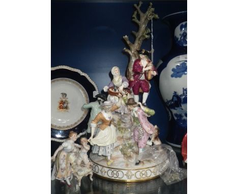 A LARGE GERMAN PORCELAIN TABLE CENTRE worked with a variety of Carousing figures around a tree