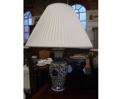 A TABLE LAMP IN THE FORM OF AN ORIENTAL BLUE AND WHITE VASE with a white pleated shade