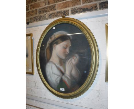 A 19TH CENTURY PASTEL PORTRAIT of a girl reading, in oval gilt frame