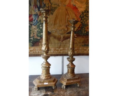 A GILTWOOD ALTAR CANDLESTICK ON CARVED PAW FEET and a smaller example with later (part) electrical fittings