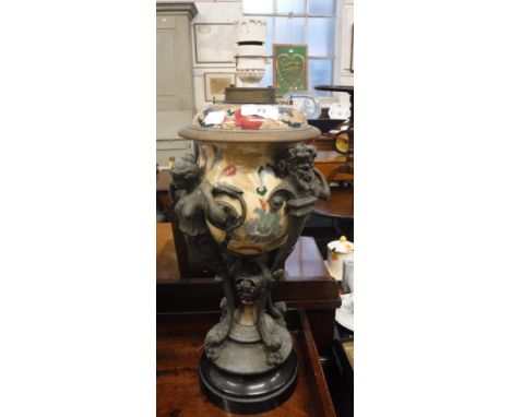 A 19TH CENTURY SPELTER AND CERAMIC OIL LAMP BASE, supported by cast spelter caryatids and satyrs. The reservoir painted with 