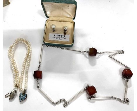 A modernist white metal and carnelian set necklace having four faceted cube shape carnelian beads joined by a chain and tubul
