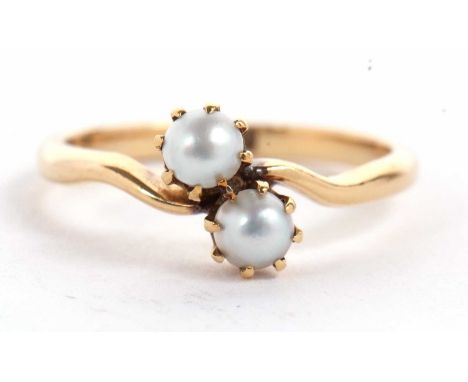 An 18ct cultured pearl crossover ring, the two pearls, claw mounted to a crossover style band stamped 18ct, size L, 2.5g