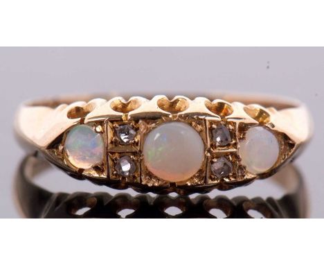 An 18ct opal and diamond ring, the three round opal cabochons interspaced with diamond highlights, with pierced gallery and p