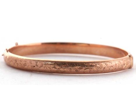 A 9ct rose gold hinged bangle, the upper half with stylised ivy leaf engraved decoration, lower half plain, approx. 6mm wide,