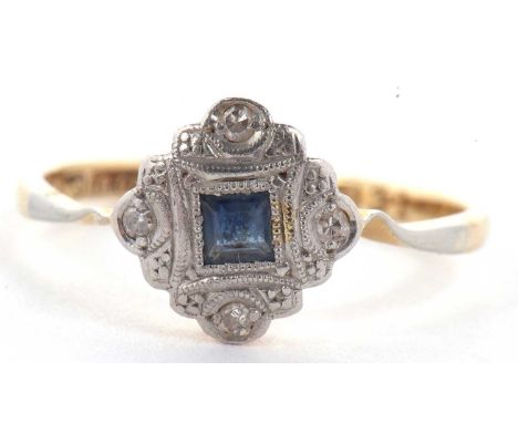 An 18ct and platinum sapphire and diamond ring, the central princess cut sapphire, inset with millegrain border to a plaque s