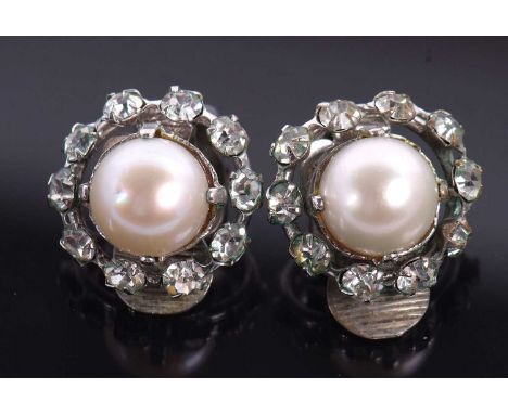 A pair of Christian Dior earclips, the central cultured pearl surrounded by white paste, set with earclips with makers mark t