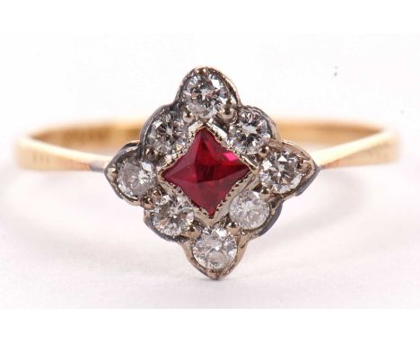 A platinum and 18ct ruby and diamond ring, the central square mixed cut ruby, set on the diagonal and surrounded by small rou