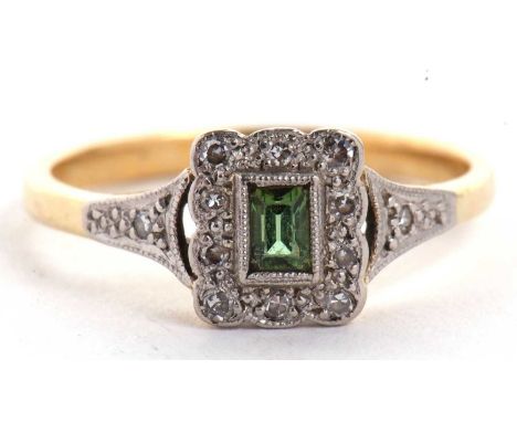 An 18ct peridot and diamond ring, the rectangular step cut peridot surrounded by small single cut diamonds, with tapered shou