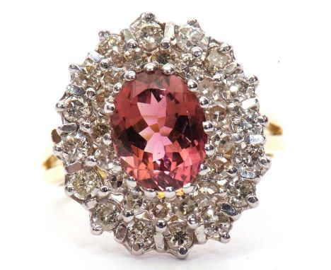 An 18ct pink tourmaline and diamond cluster ring, the oval pink tourmaline, claw mounted and surrounded by a row of single cu