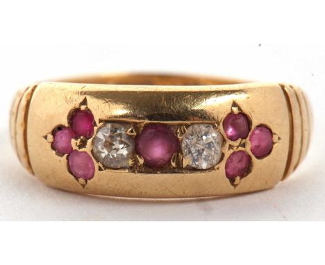 An 18ct ruby and diamond ring, the central round ruby set to either side with a round diamond and a further trefoil of small 