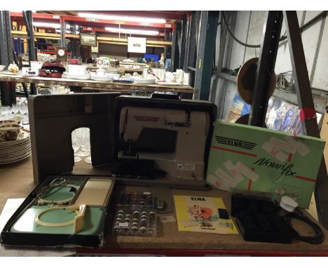 A CASED 1960 ELNA SUPERMATIC SEWING MACHINE WITH VARIOUS ATTACHMENTS TO INCLUDE A KNEE BAR, FORTY EIGHT BOXED CAMS TO INCLUDE