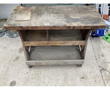 A VINTAGE WOODEN WORK BENCH WITH CAST IRON WHEELED BASE 