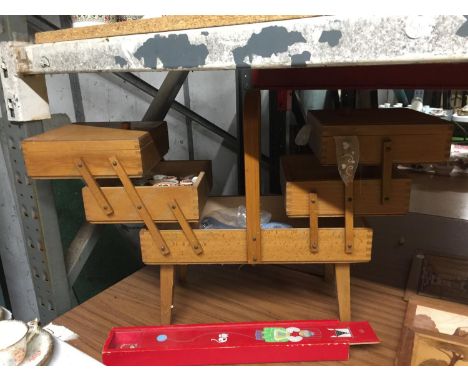 A VINTAGE CANTILEVER SEWING BOX WITH CONTENTS PLUS A KNITTING NEEDLE CASE WITH NEEDLES 