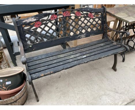 A WOODEN SLATTED GARDEN BENCH WITH CAST ENDS AND FLORAL BACK 