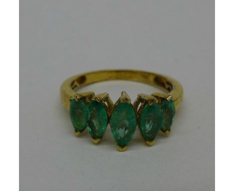 A silver gilt ring set with five emeralds, P
