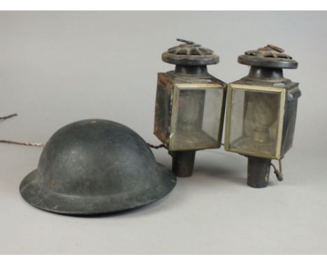 A pair of coaching lamps converting to electricity and a lined warden’s helmet