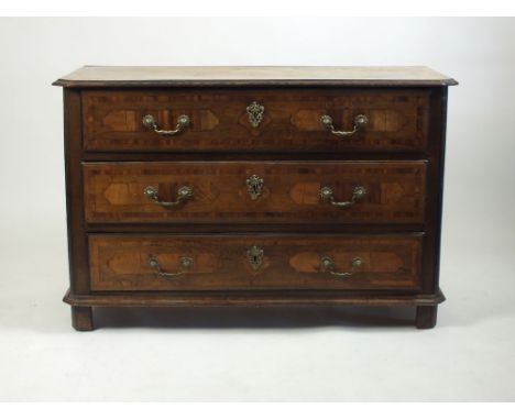 A South German cross-banded oak and inlaid commode, 18th century, the bevelled rectangular top with canted corners above thre