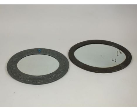A Liberty's style pewter framed oval wall mirror inset with a Ruskin type blue ceramic plaque and with grape and vine embosse