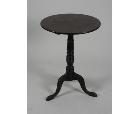 A George III mahogany tripod table, the circular tilt-top above a ring turned baluster column and three down-curved legs and 