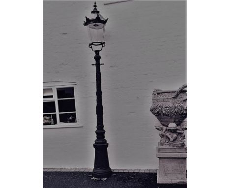 A cast iron lantern style street lamp, with hexagonal tapering lantern on a leaf and berry cast tapering circular column and 