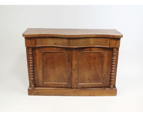 A Victorian mahogany chiffonier base, the serpentine front top above a conforming drawer and two indented panel cupboard door