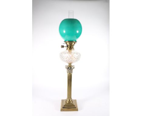 Antique brass Corinthian column paraffin lamp having cut glass reservoir and green glass shade, 82cm tall to top of the funne