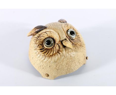 Early plastic table bell in the form of an owls head, the nose being the button, having a clockwork mechanism, 9.5cm diameter