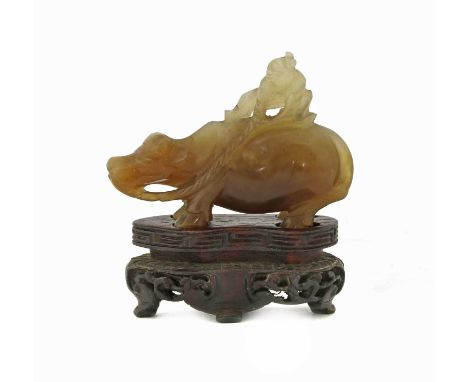 A Chinese jade carving,late Qing dynasty, of a boy seated on the back of a buffalo, 5.5cm long, wood stand (2)清晚期 玉雕童子牧牛摆件 连木