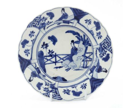 A Chinese blue and white saucer, Kangxi (1662-1722), the rounded sides rising from a circular foot to a flared lobed rim, pai