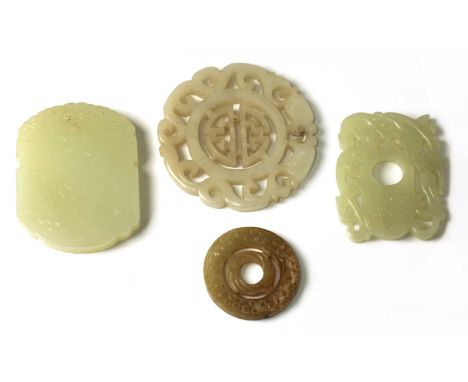 A collection of four Chinese jade pendants, comprising: one carved with a crane by bamboo, 5.7cm long, one pierced and carved