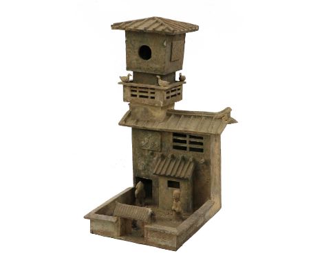 A Chinese earthenware model,probably Han dynasty (206 BC - AD 220), of a barn with two figures, dogs roaming in the yard and 
