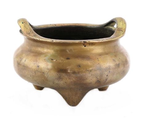 A Chinese bronze incense burner,Qing dynasty (1644-1911), the compressed globular body on three stud feet with two loop handl