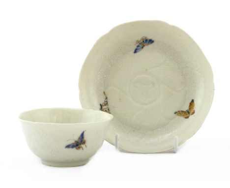 A Chinese famille rose cup and saucer,Yongzheng (1723-1735), the cup with rounded sides moulded with petals in relief, rising