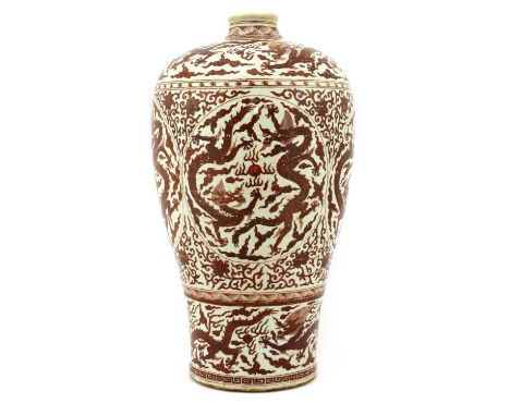 A Chinese iron-red meiping vase,potted with a high rounded shoulder below a short-waisted neck, and tapering elegantly toward