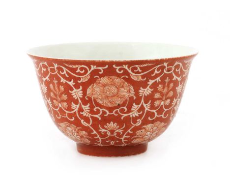 A Chinese iron red-glazed bowl, the rounded sides rising from a circular foot to a flared rim, painted with scrolling lotus a
