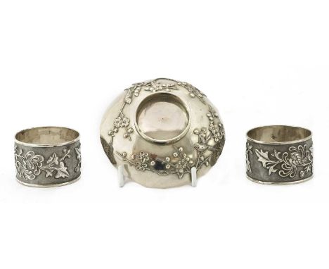 A pair of Chinese export silver napkin rings, early 20th century, each of cylindrical form, decorated in relief with a vacant