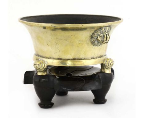 A Chinese bronze incense burner,Qing dynasty (1644-1911), of tapering form with a flared mouth, on three scroll feet, Buddhis