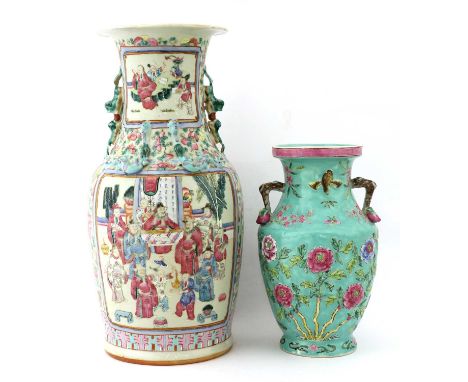 A Chinese famille rose vase, 19th century, of baluster form, painted with figures in a sitting room, in shaped panels surroun