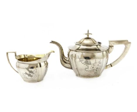 A Chinese export silver teapot, early 20th century, of shaped oval form, engraved with birds and flowers to one side and carp