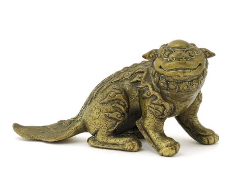 A Chinese bronze paperweight,Qing dynasty (1644-1911), in the shape of a Buddhist lion, seated on its haunches with its torso