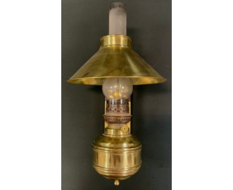An early 20th century wall mounted adjustable brass oil lamp, converted for use with electricity, 43cm tall. 
