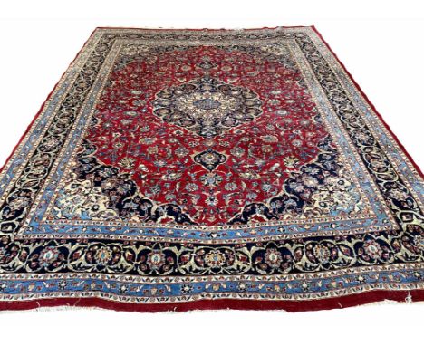 MASHAD CARPET, 385cm x 305cm, central medallion on a palmette and vine field within corresponding spandrels and borders.