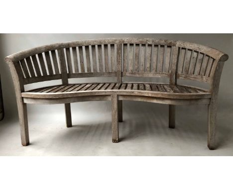 BANANA BENCH, silvering weathered teak of slatted form and bowed outline, 155cm W.