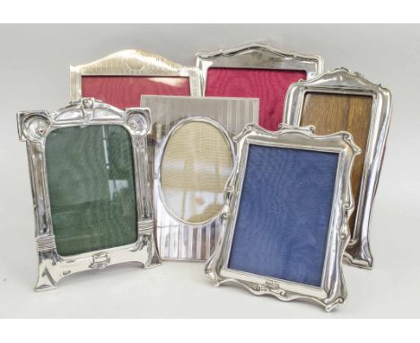 PHOTOGRAPH FRAMES, a collection of six, early 20th century silver, including Walker &amp; Hall examples, largest 27cm x 19cm.