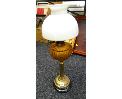 A brass table lamp in the style of an oil lamp